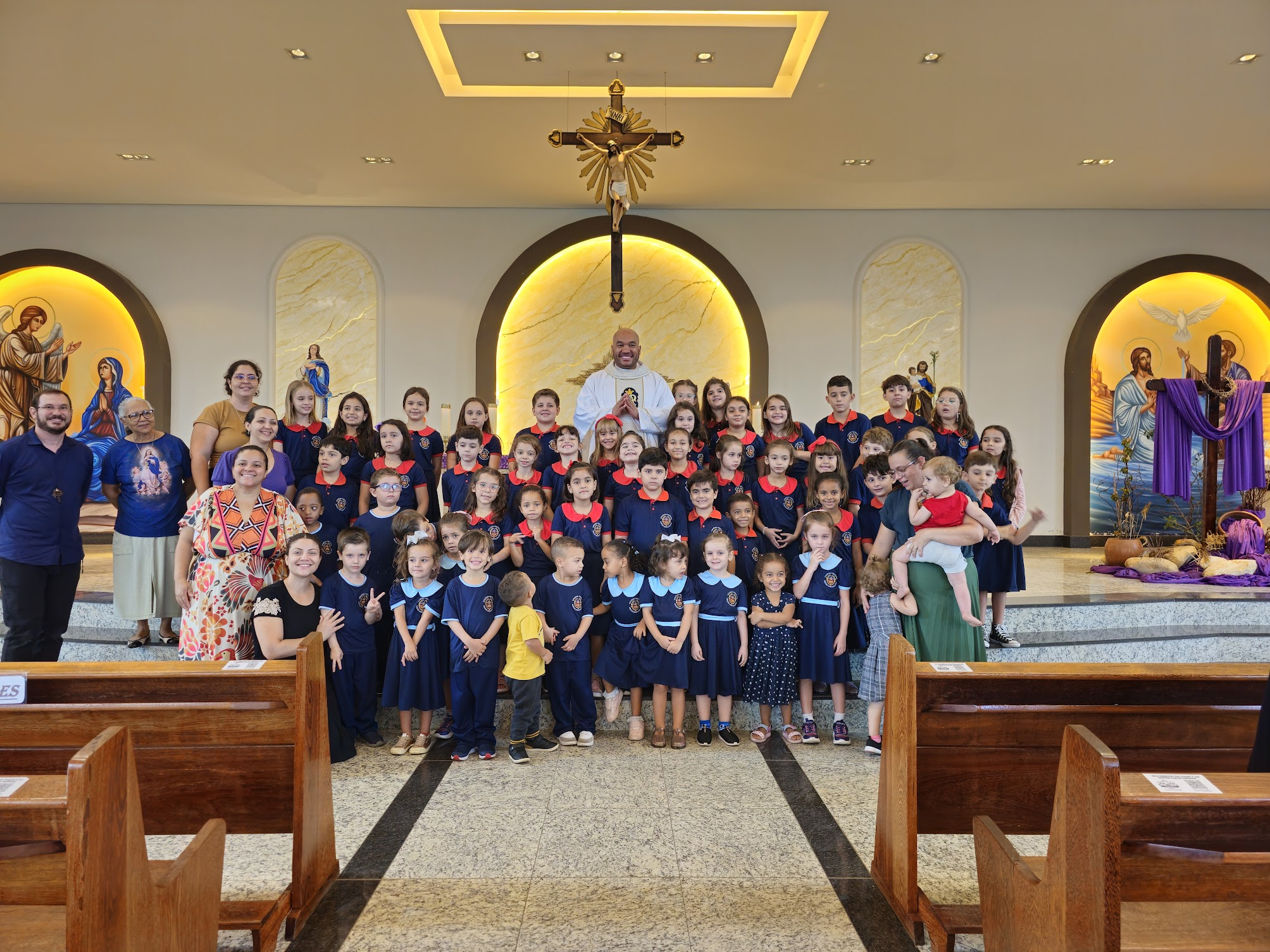 Alunos uniformizados em celebração com o Diretor Espiritual